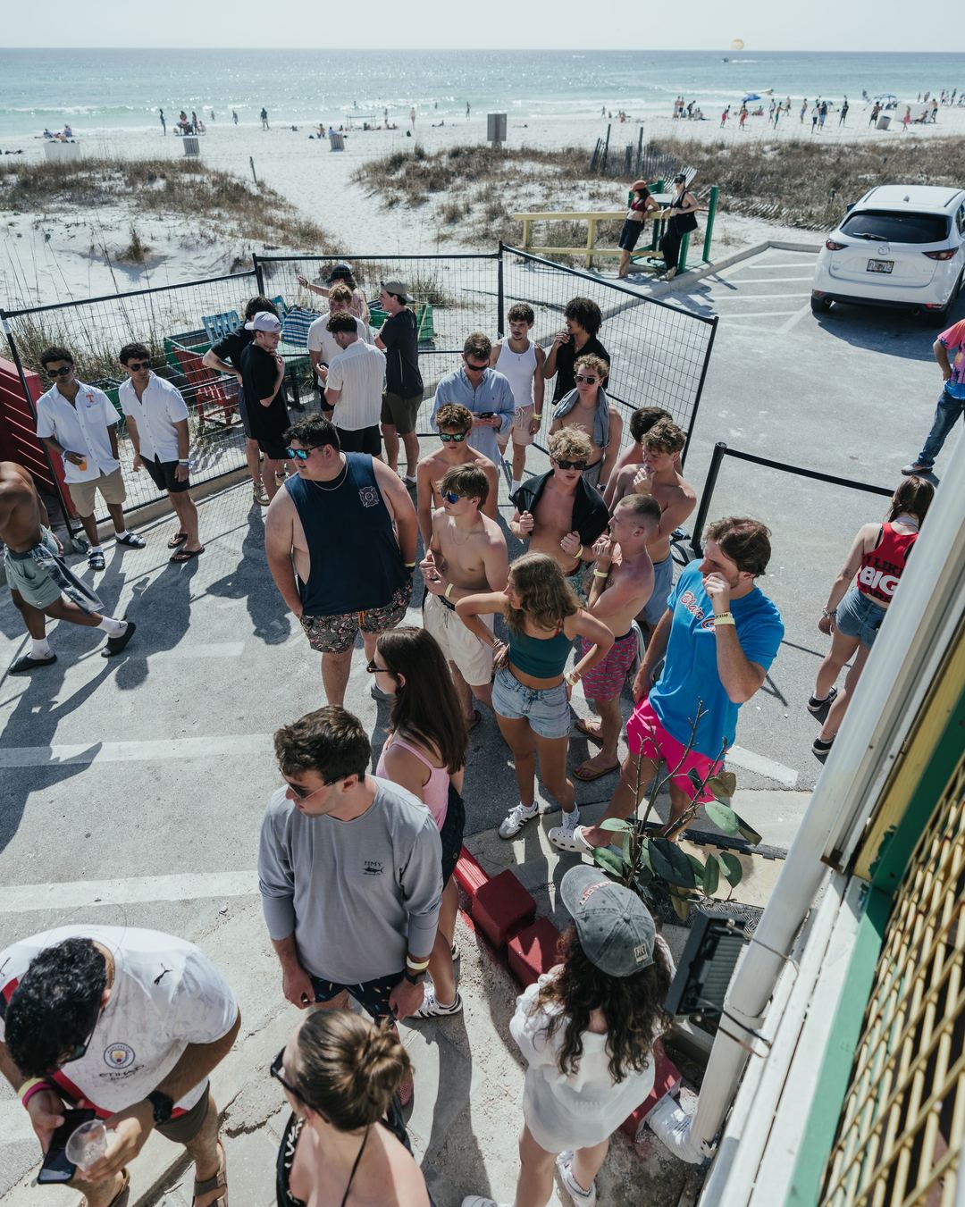 Spring breakers walking down a beach access path on a sunny day