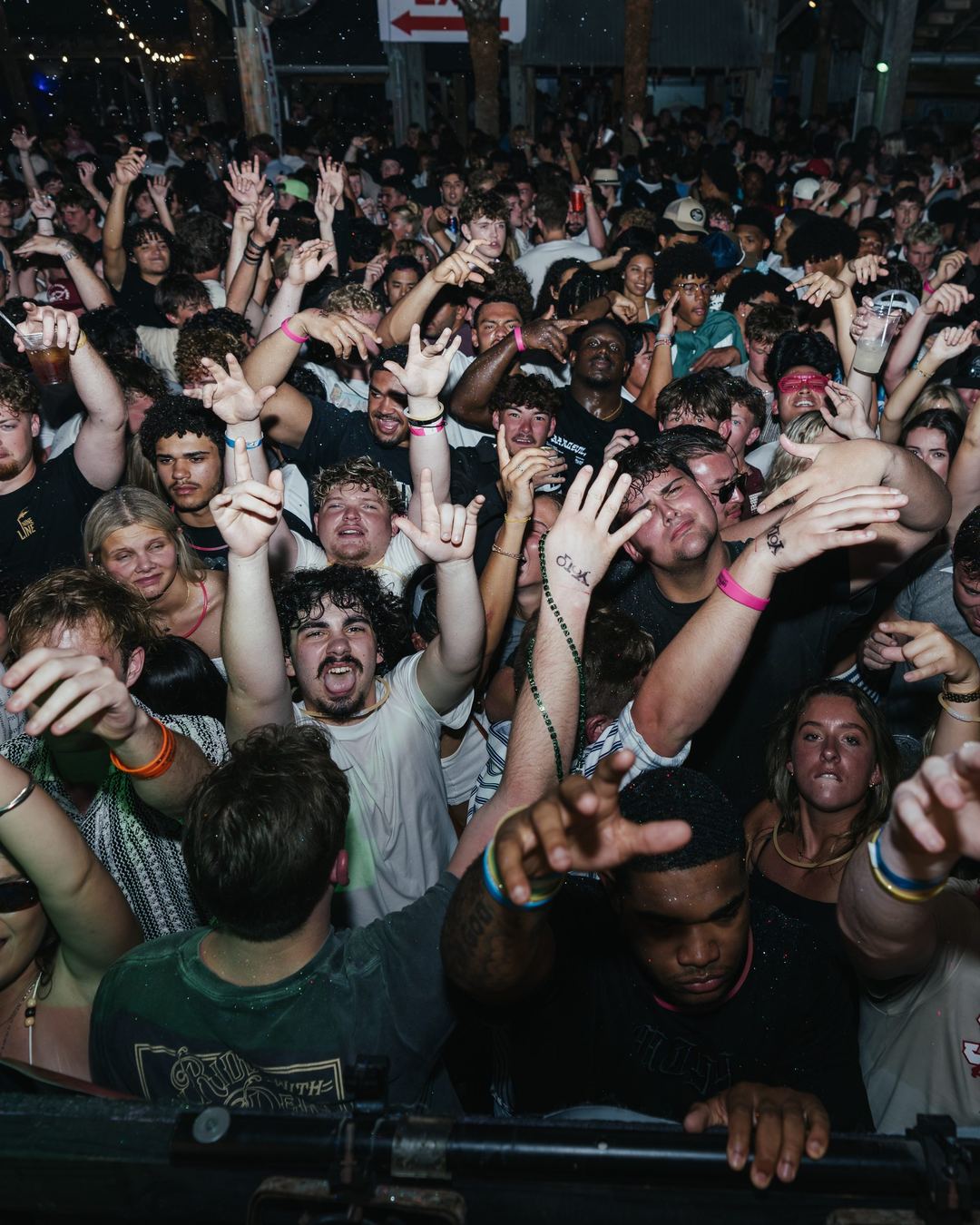 Spring breakers with their hands up at the front barricade