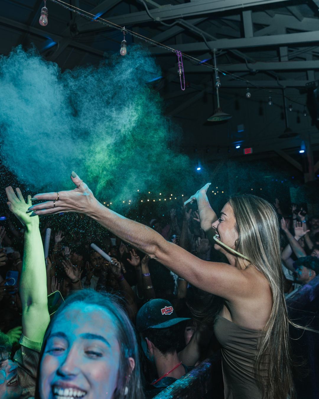 Friends throwing blue color powder at a spring break party