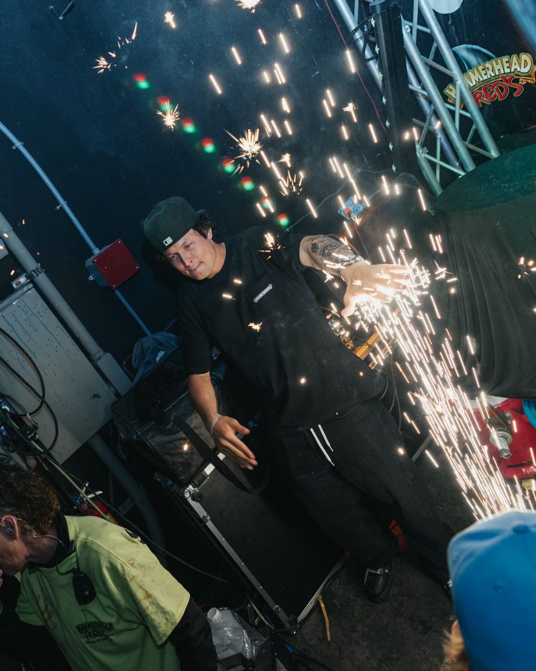 A staffer carrying sparklers past the stage at a spring break party